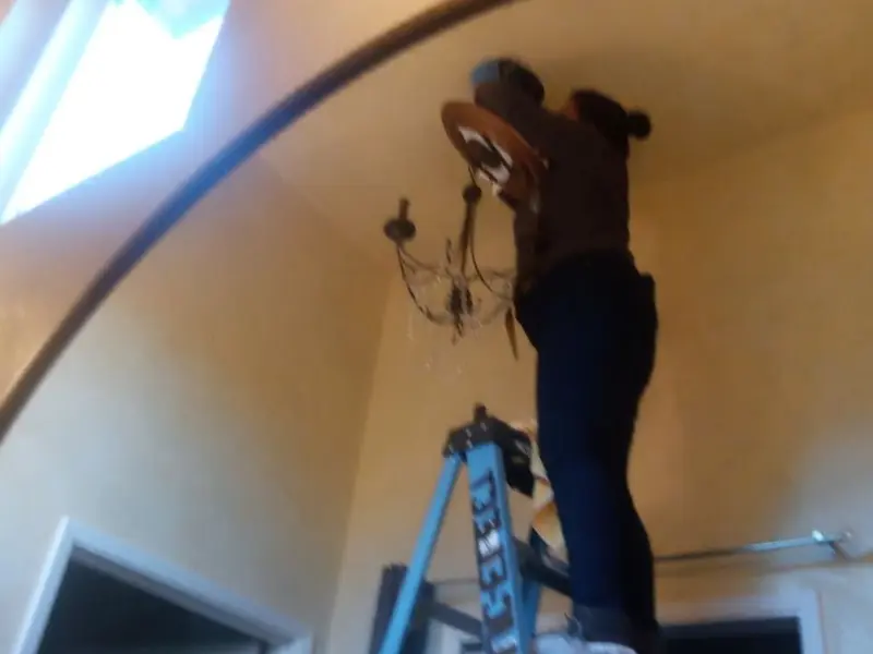 Electrician installing a chandelier in a East Flat Rock residence